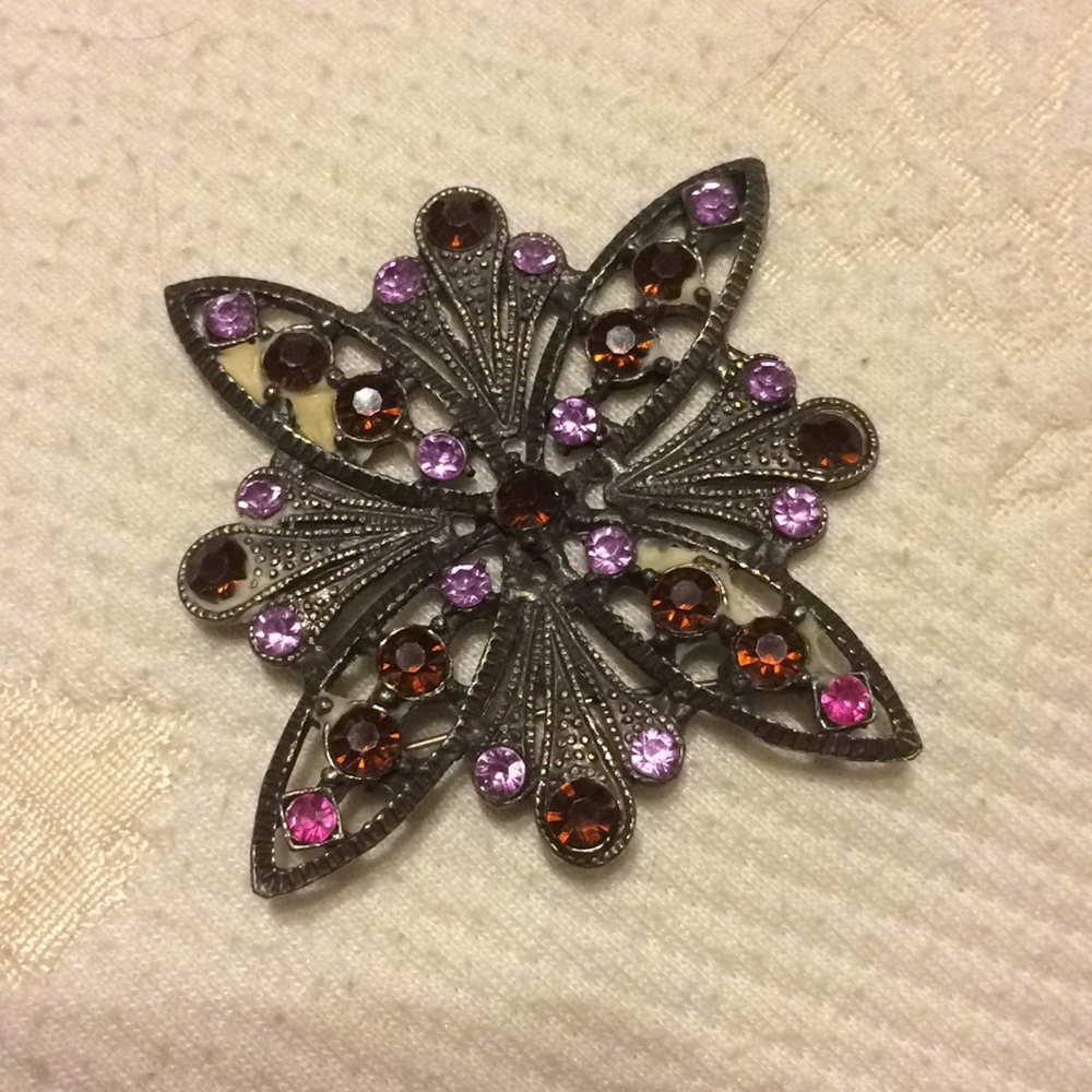 Antique brooch with purple rhinestones.